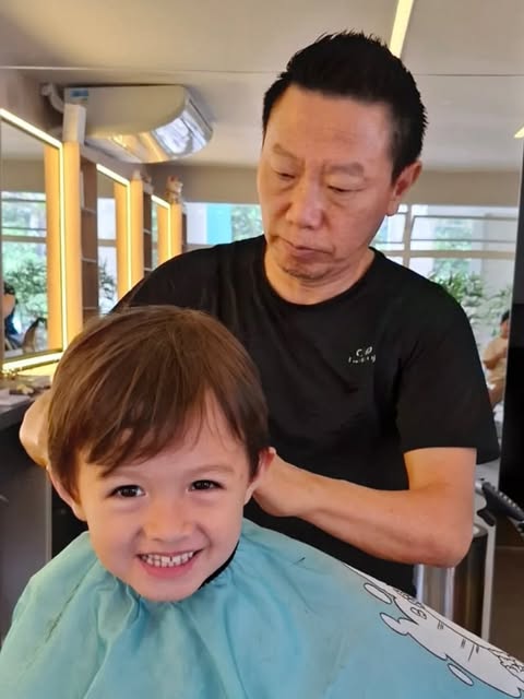 Sérgio cortando o cabelo de uma criança no salão